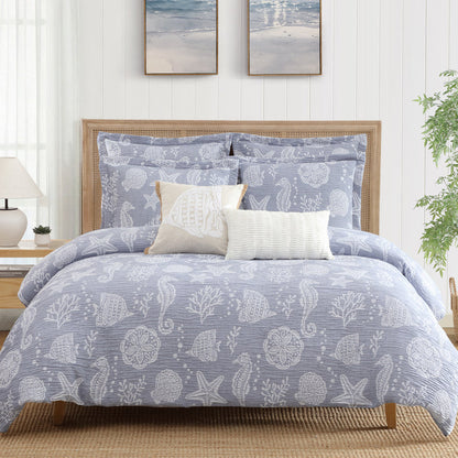 Bed with blue and white patterned bedding in a bedroom setting.